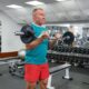 A male pensioner doing barbell exercises at the gym