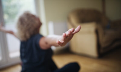 Senior woman doing yoga at home. FIngers closeup.